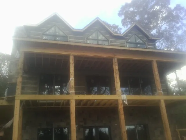 Dormers and porch framing on a large log home under construction — Roof Coating work by our crew in Gilroy