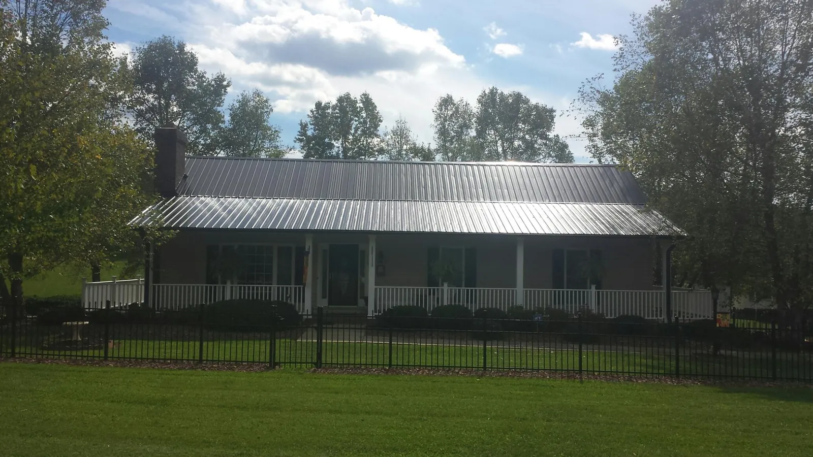 Gray metal roof on a brick ranch with a full width front porch — Gutter Guard Installation work by our crew in Gilroy