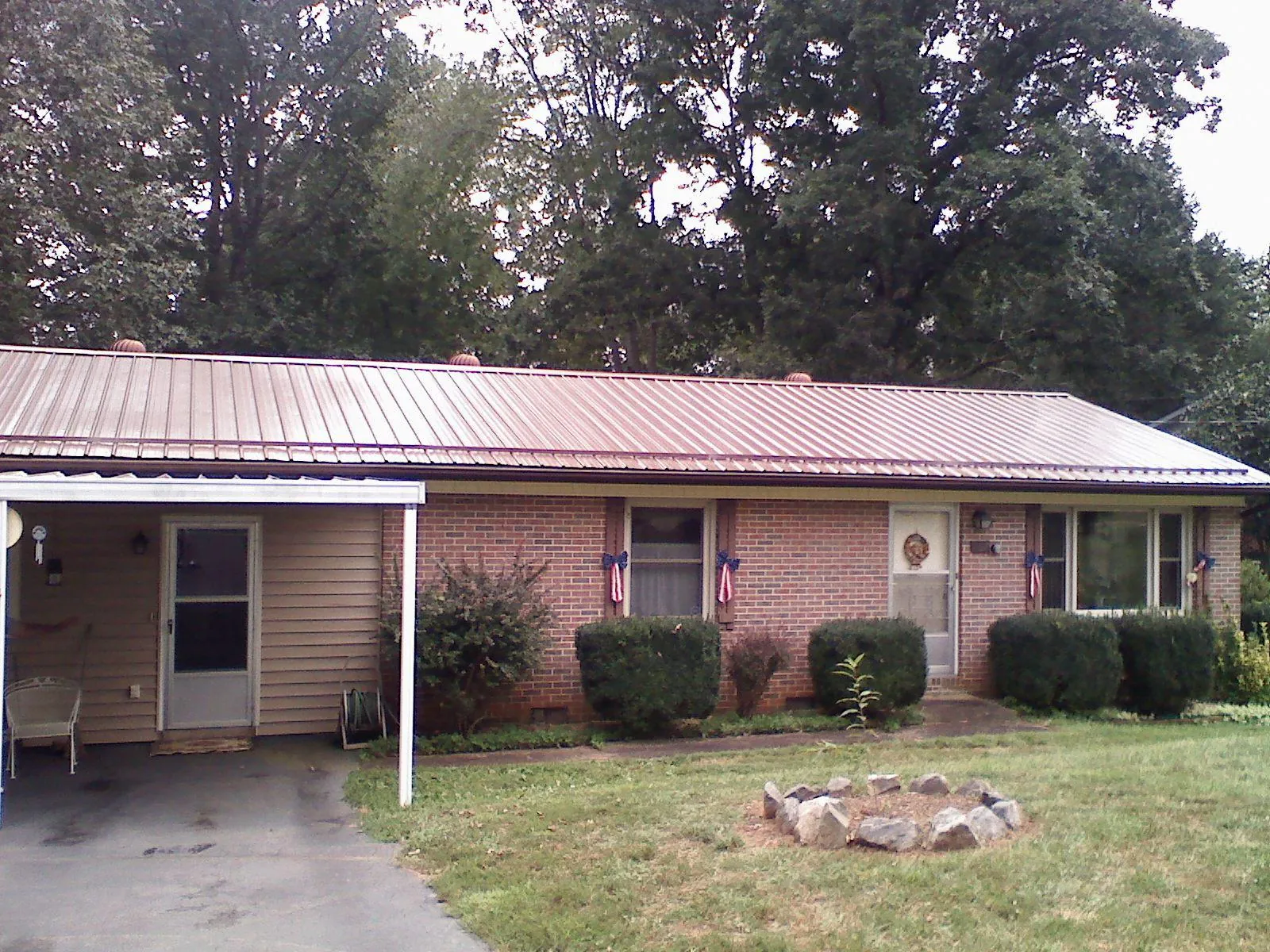 Bronze metal roof and carport on a brick ranch home — Roof Repair work by our crew in Gilroy